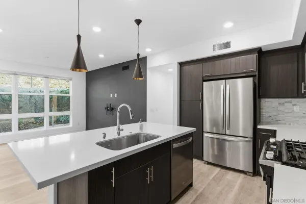 a kitchen with stainless steel appliances a sink a counter space and a window