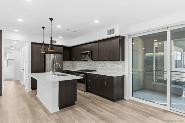 a large kitchen with stainless steel appliances kitchen island granite countertop a refrigerator and a sink