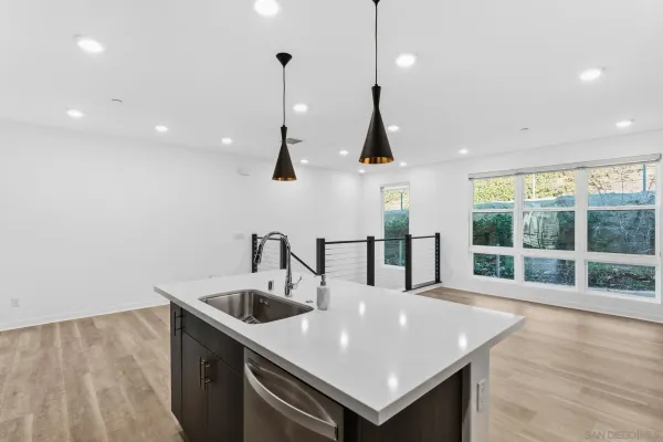 a kitchen with stainless steel appliances a sink a large window and wooden floor