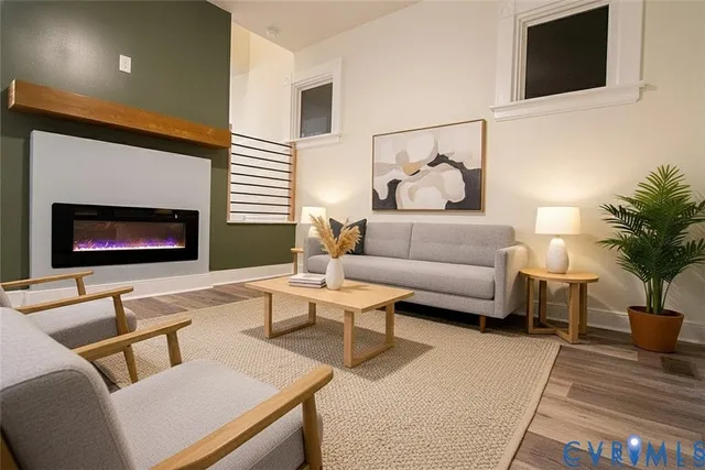 a living room with furniture a flat screen tv and a fireplace