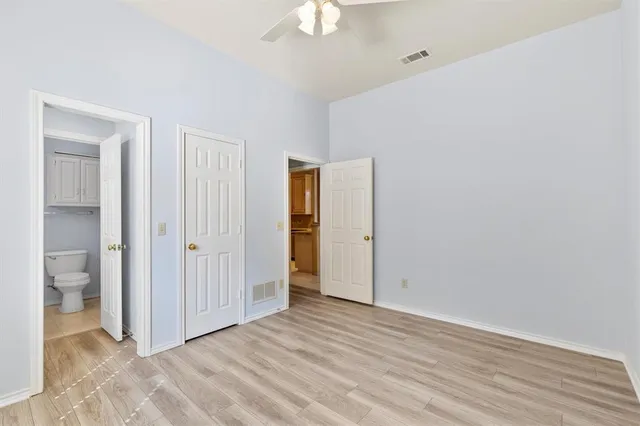 a view of an empty room with window and bathroom