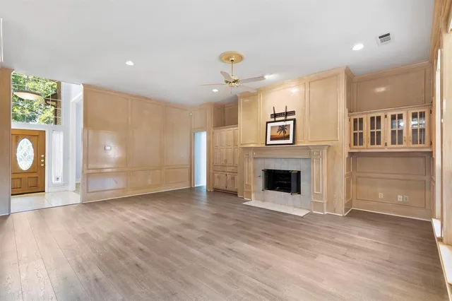 an empty room with windows and fireplace