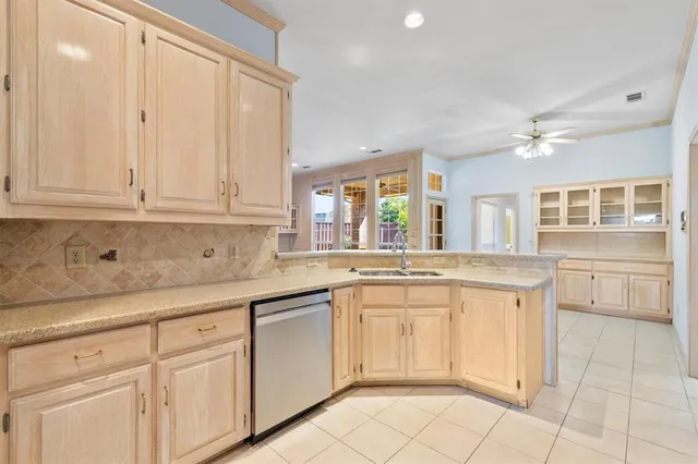 a kitchen with white cabinets and sink