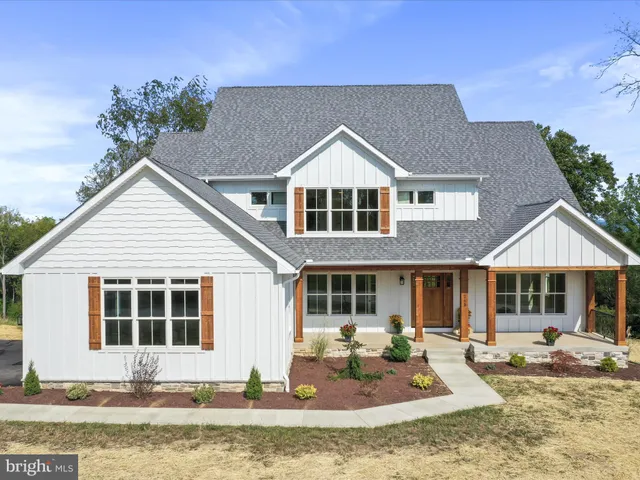 a front view of a house with garden and sitting space