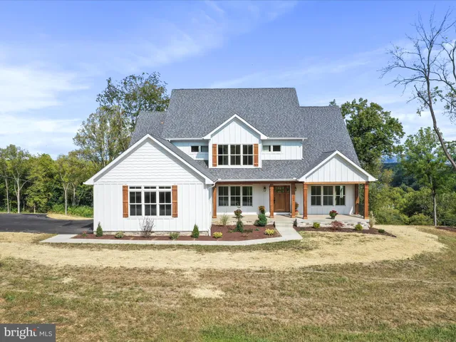 a front view of a house with a yard and lake view