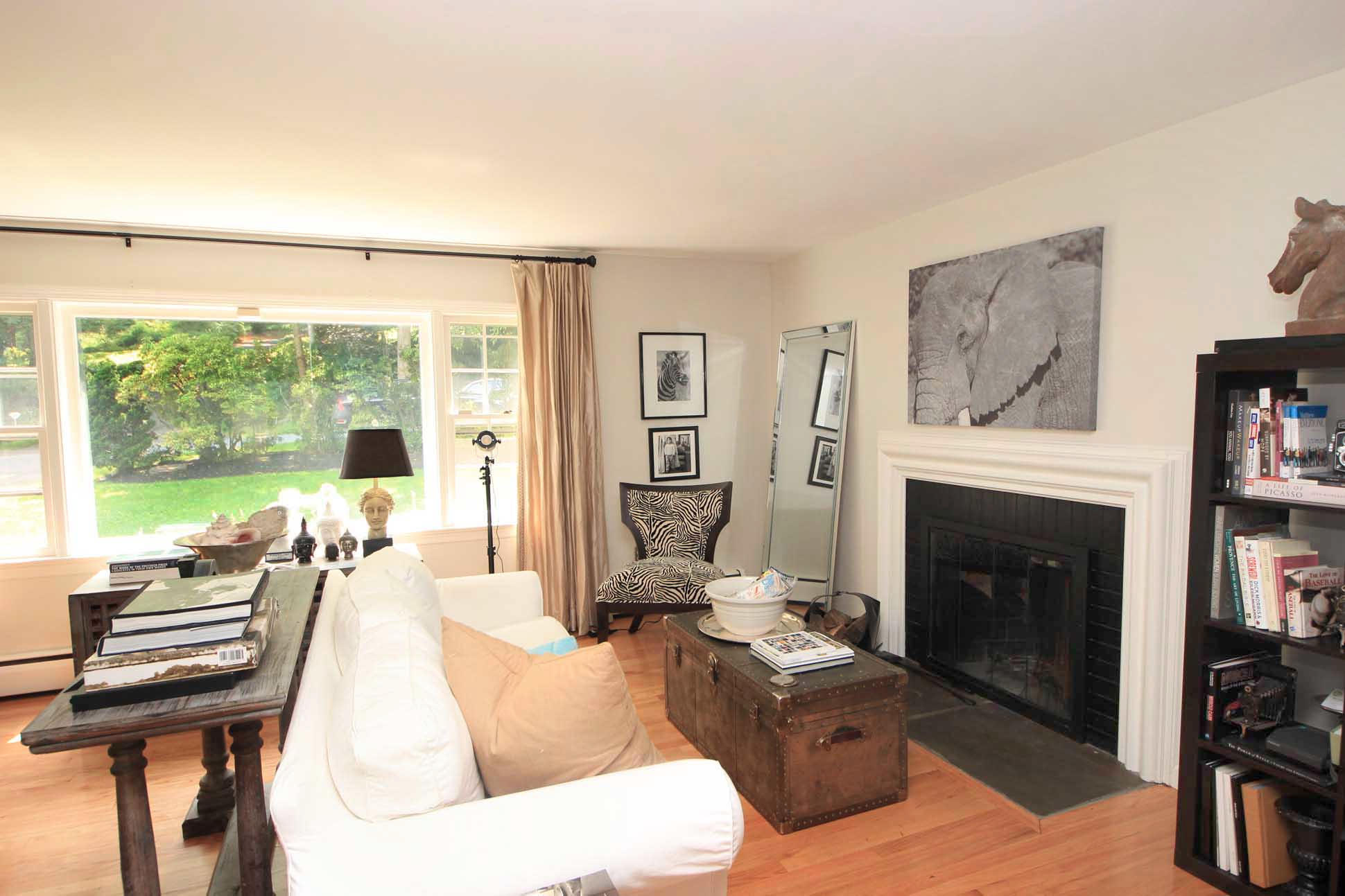 43 Rural Drive New Canaan, CT 06840 - Photo 3 of 26 a living room with furniture a fireplace and a floor to ceiling window