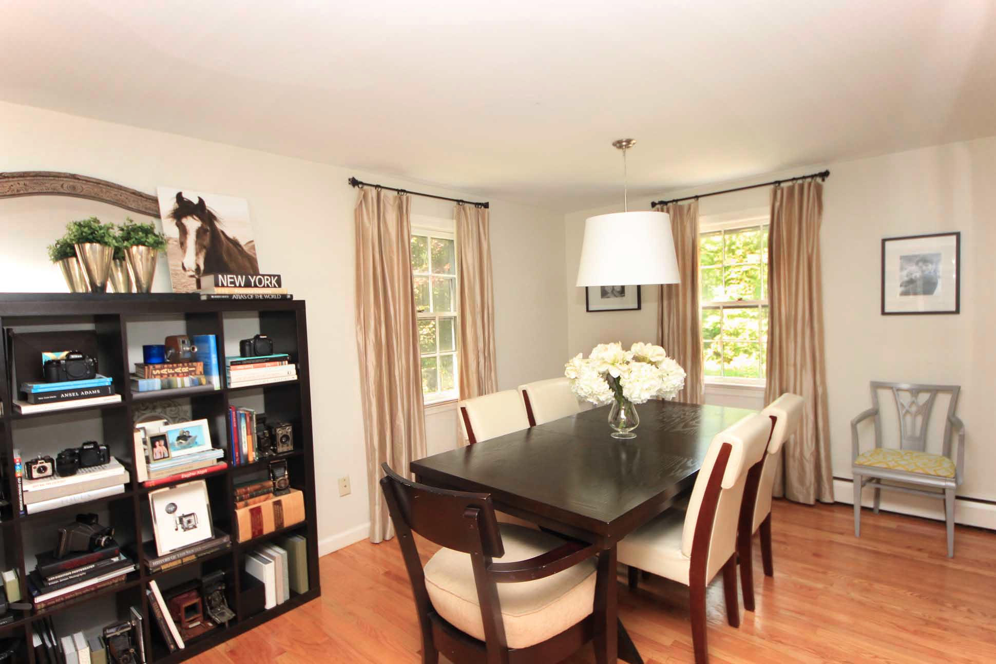 43 Rural Drive New Canaan, CT 06840 - Photo 6 of 26 a view of a dining room with furniture and a book shelf