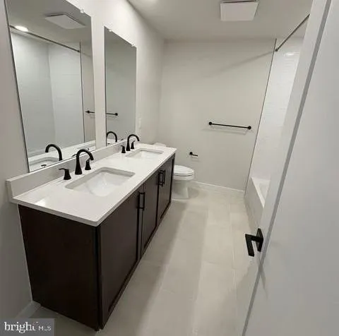 a bathroom with a sink and mirror with toilet