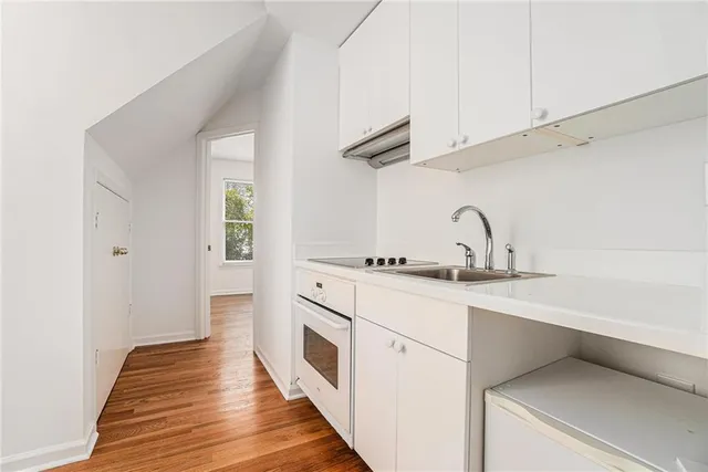 a kitchen with a sink a stove and cabinets