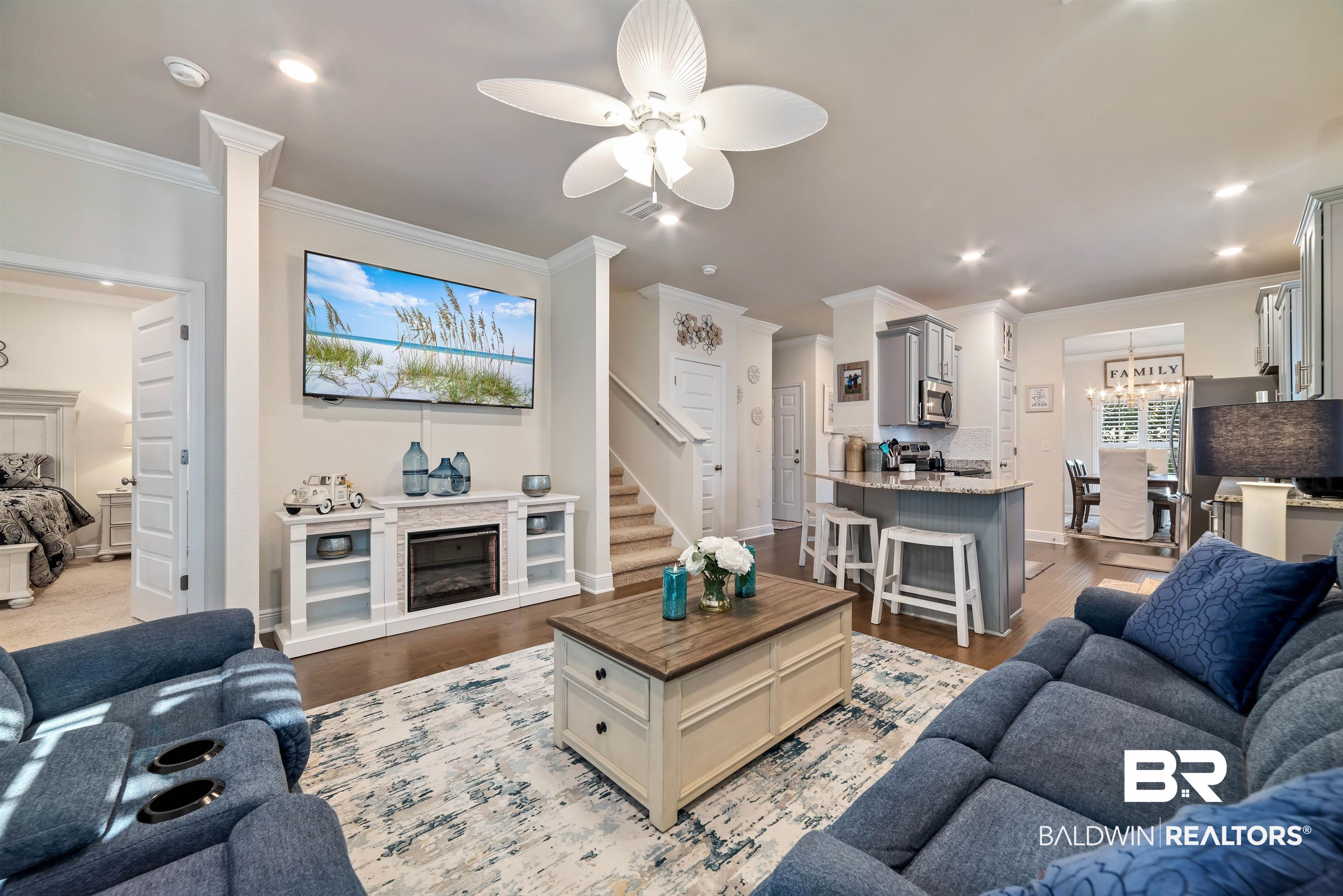 1290 Mako Loop Gulf Shores, AL 36542 - Photo 12 of 50 Living area featuring a glass covered fireplace, ornamental molding, wood finished floors, stairs, and recessed lighting