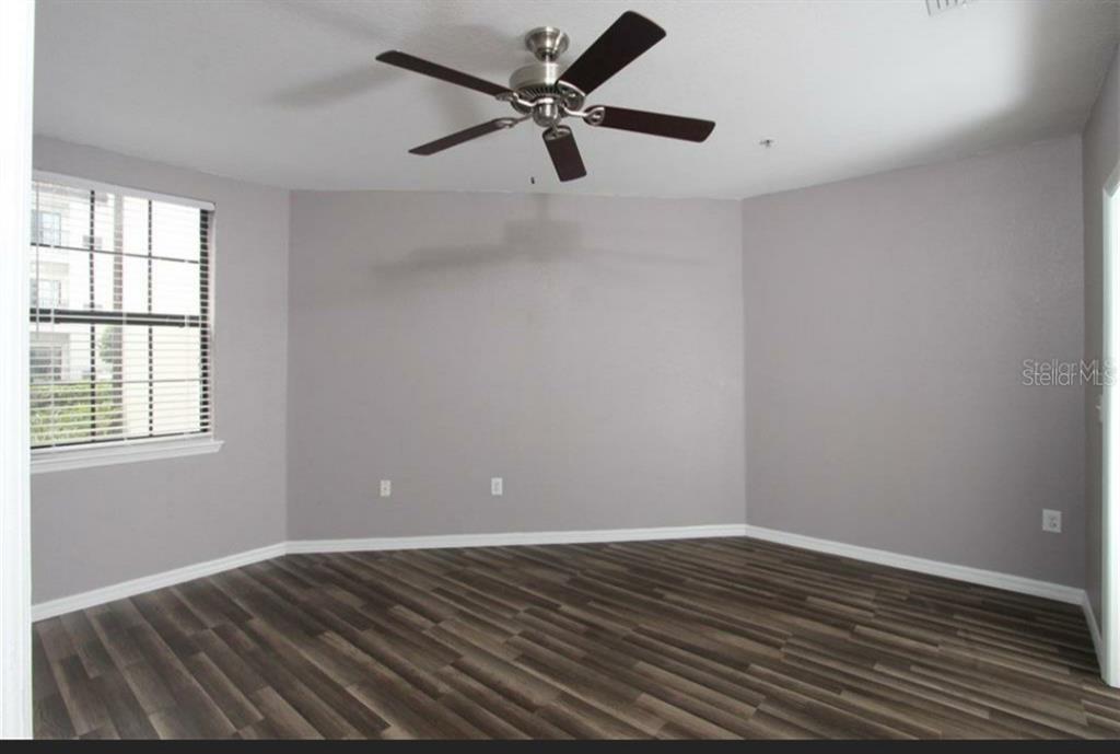 5550 East Michigan Street, Unit 3120 Orlando, FL 32822 - Photo 11 of 17 a view of an empty room with window and wooden floor