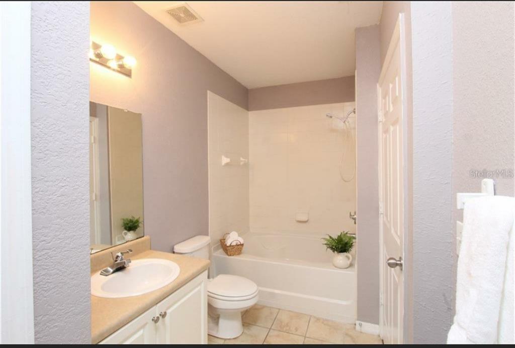 5550 East Michigan Street, Unit 3120 Orlando, FL 32822 - Photo 14 of 17 a bathroom with a bathtub shower sink mirror and toilet