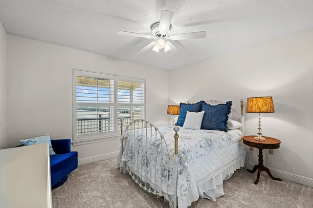 an empty room with a chandelier fan and windows