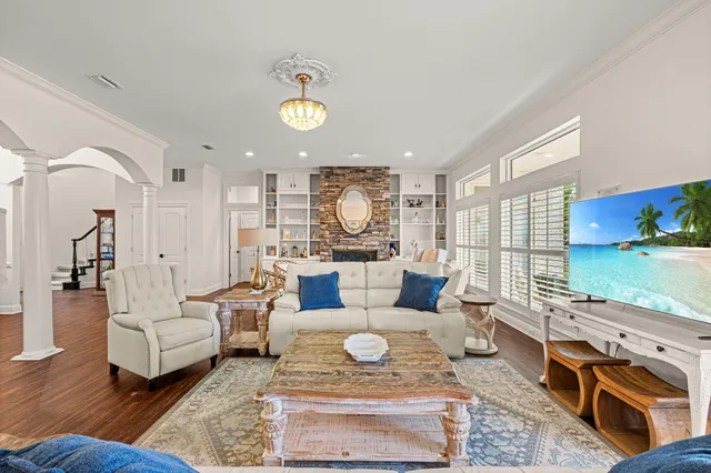 a dining room with furniture a chandelier and wooden floor