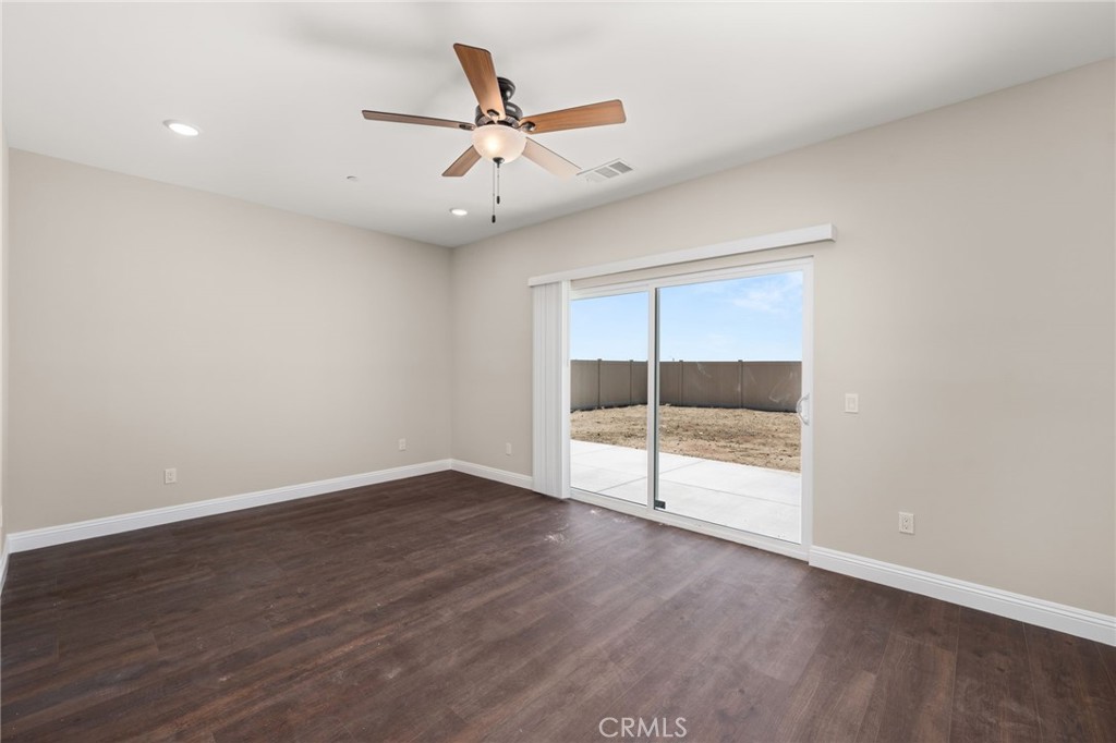 1243 Ansley Lane Mentone, CA 92359 - Photo 13 of 24 an empty room with wooden floor and windows