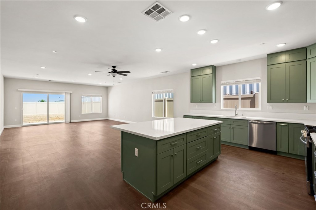1243 Ansley Lane Mentone, CA 92359 - Photo 5 of 24 a kitchen with granite countertop a sink cabinets and wooden floor