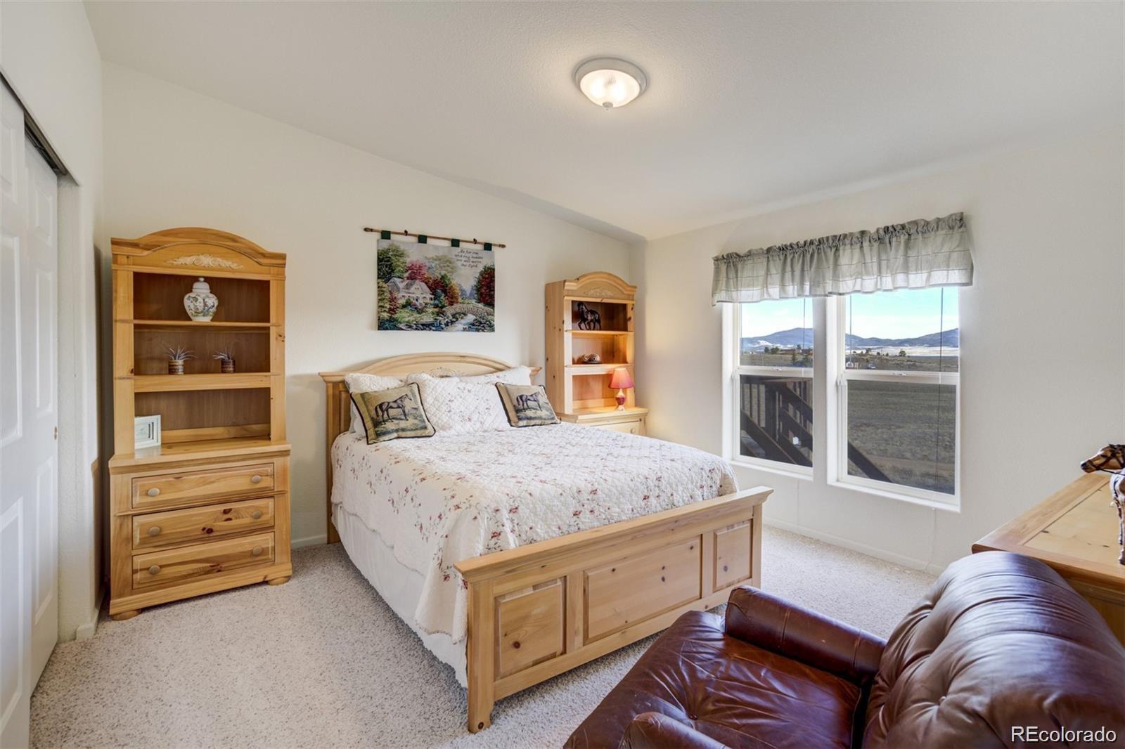 688 Tiara Road Lake George, CO 80827 - Photo 19 of 46 a bedroom with a bed and a dresser next to a window