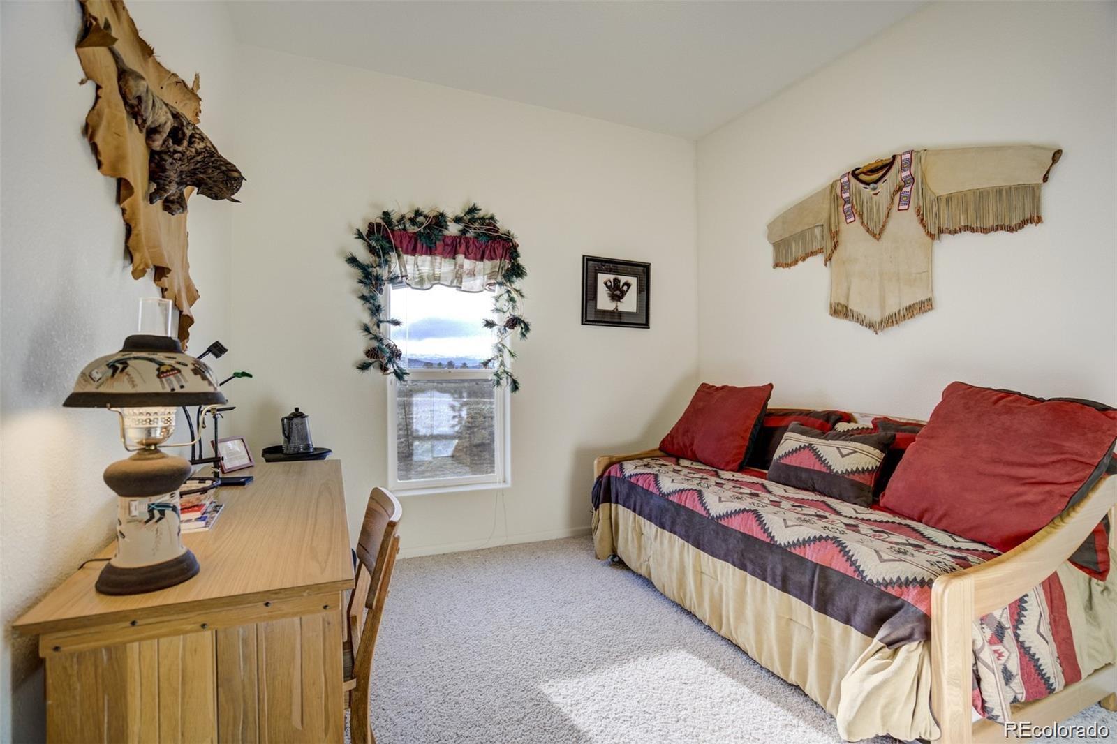 688 Tiara Road Lake George, CO 80827 - Photo 20 of 46 a bedroom with a bed and wooden floor
