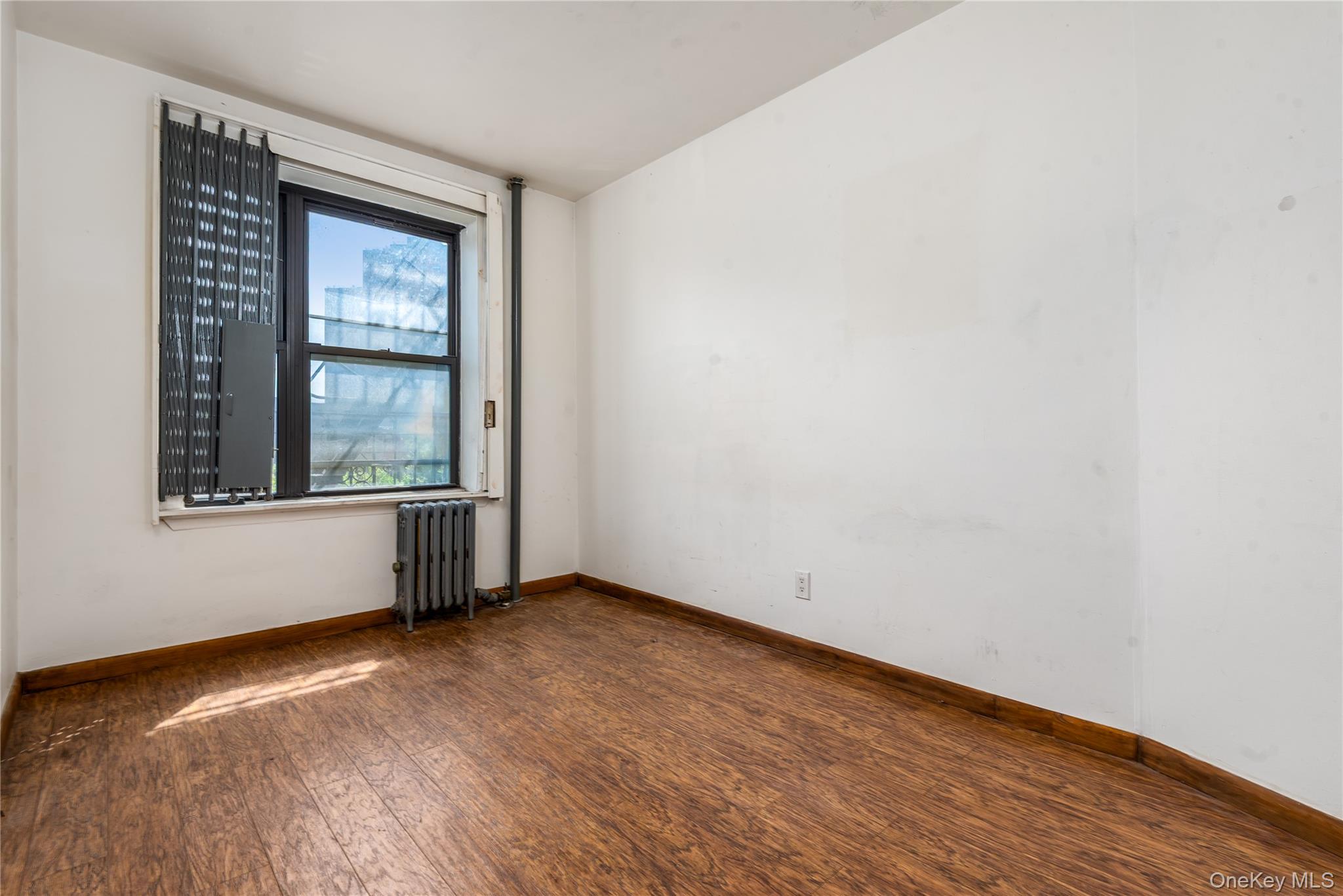95 South 10th Street, Unit 22 Brooklyn, NY 11249 - Photo 7 of 8 Spare room with dark wood-type flooring and radiator