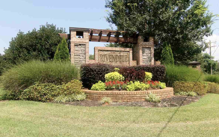 Welcoming community entrance with meticulously landscaped grounds and architectural detailing.