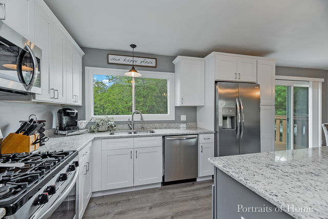 346 Rockhurst Road Bolingbrook, IL 60440 - Photo 8 of 19 a kitchen with stainless steel appliances granite countertop a stove a sink dishwasher and refrigerator with wooden floor