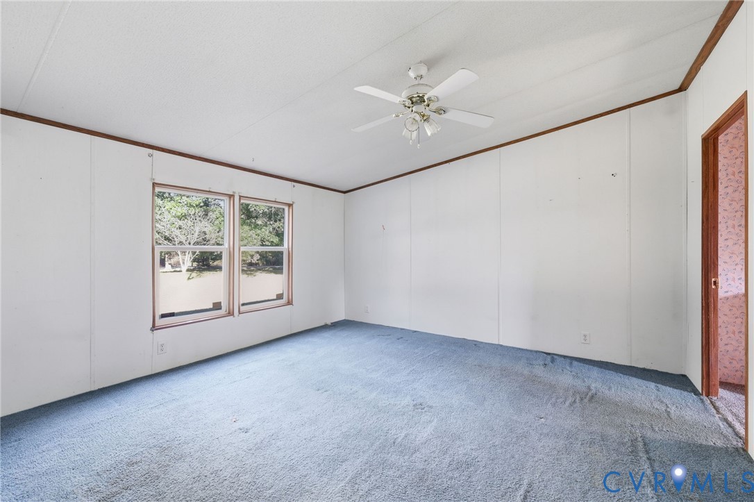 7410 Richmond Road Amelia Court House, VA 23002 - Photo 13 of 39 an empty room with chandelier fan and windows