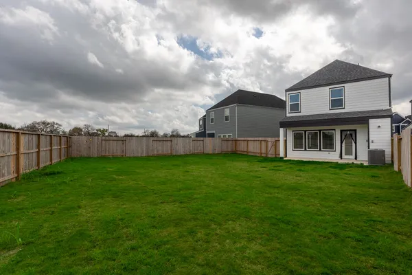 a view of a house with a big yard and large trees