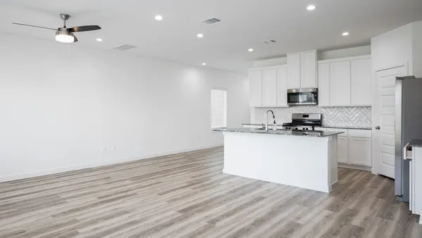 a kitchen with a refrigerator and white cabinets