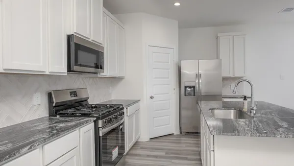 a kitchen with stainless steel appliances granite countertop a sink stove and refrigerator