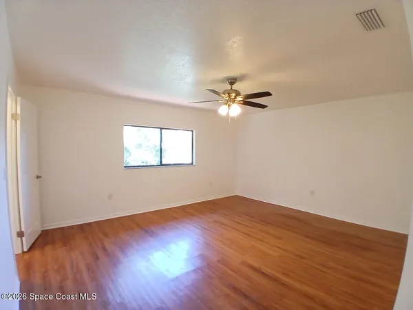 a view of an empty room with wooden floor