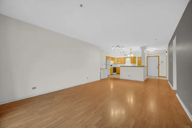 a view of a big room with wooden floor and windows