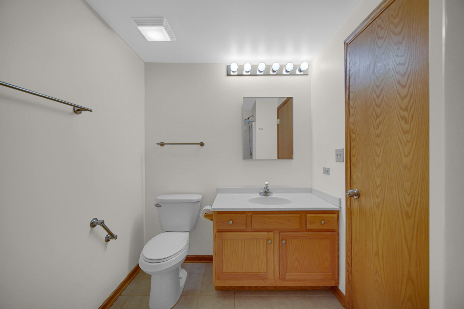 18065 Harwood Avenue, Unit A Homewood, IL 60430 - Photo 19 of 25 a bathroom with a toilet sink and mirror