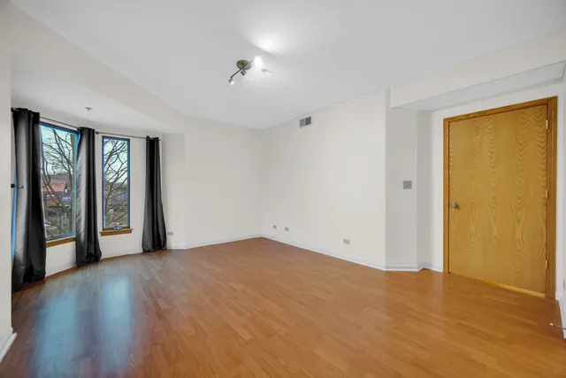 a view of an empty room with glass door and a window
