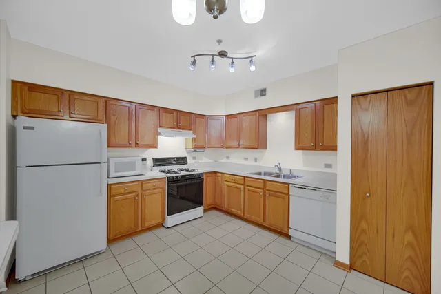 a kitchen with stainless steel appliances granite countertop a refrigerator and a sink