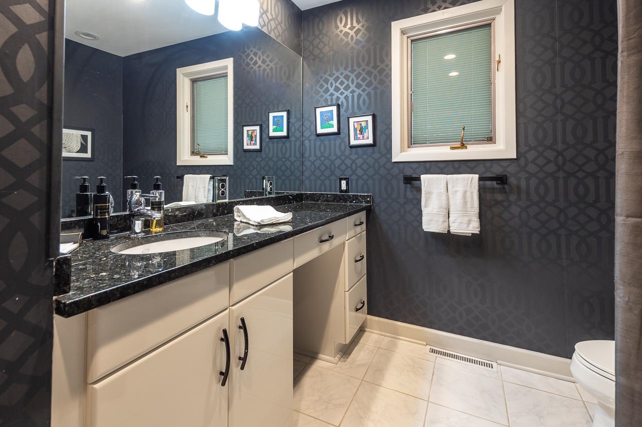 110 Wallace Road Memphis, TN 38117 - Photo 13 of 25 a bathroom with a granite countertop sink a toilet and mirror