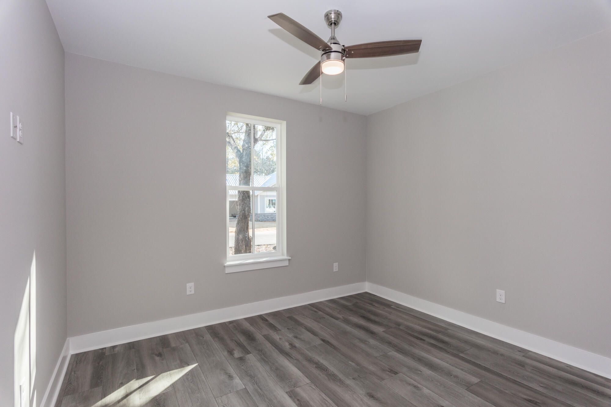 190 Bear Creek Boulevard Freeport, FL 32439 - Photo 40 of 85 an empty room with wooden floor windows and ceiling fan