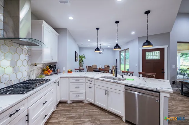a kitchen with stainless steel appliances a sink stove and cabinets