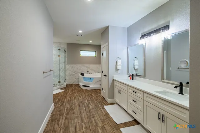 a spacious bathroom with a double vanity sink and a mirror