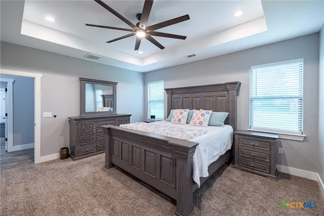 a bedroom with a large bed and a chandelier