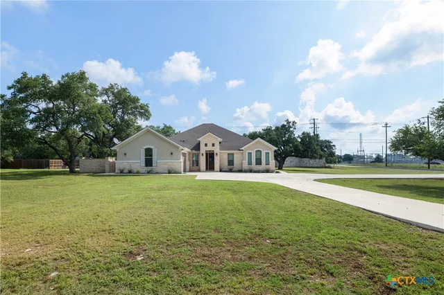 a view of a house with a big yard and a large tree