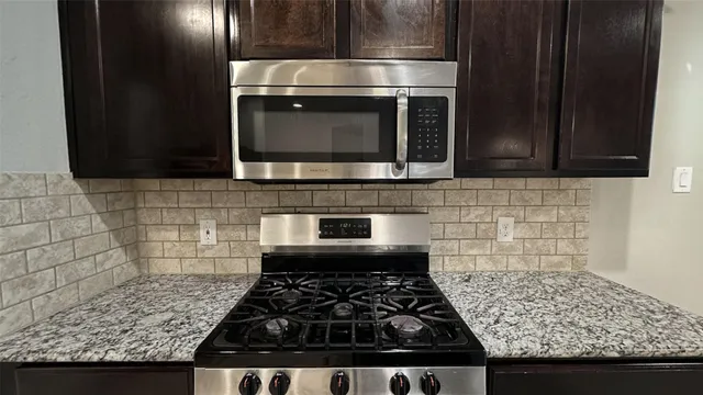 a view of a livingroom with a chandelier fan and a kitchen