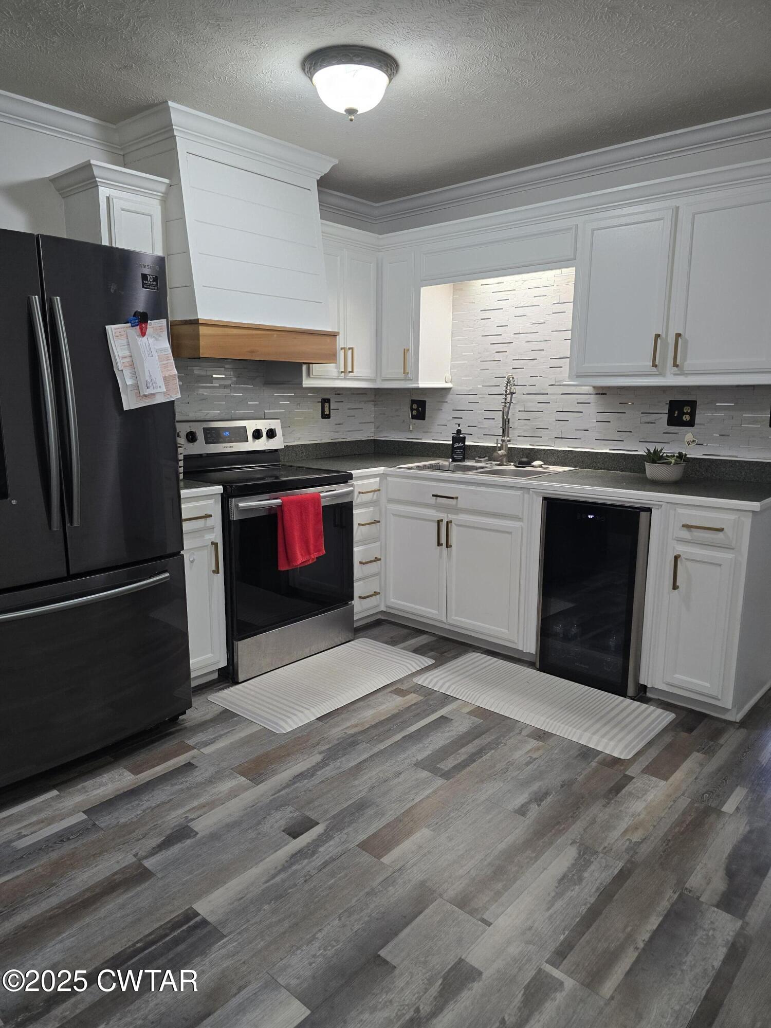 143 Elizabeth Cove Selmer, TN 38375 - Photo 2 of 14 a kitchen with granite countertop stainless steel appliances and wooden cabinets