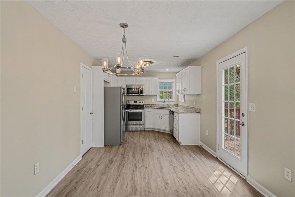 10 Wilbur Way Covington, GA 30016 - Photo 5 of 22 a kitchen with stainless steel appliances granite countertop a sink cabinets and wooden floor
