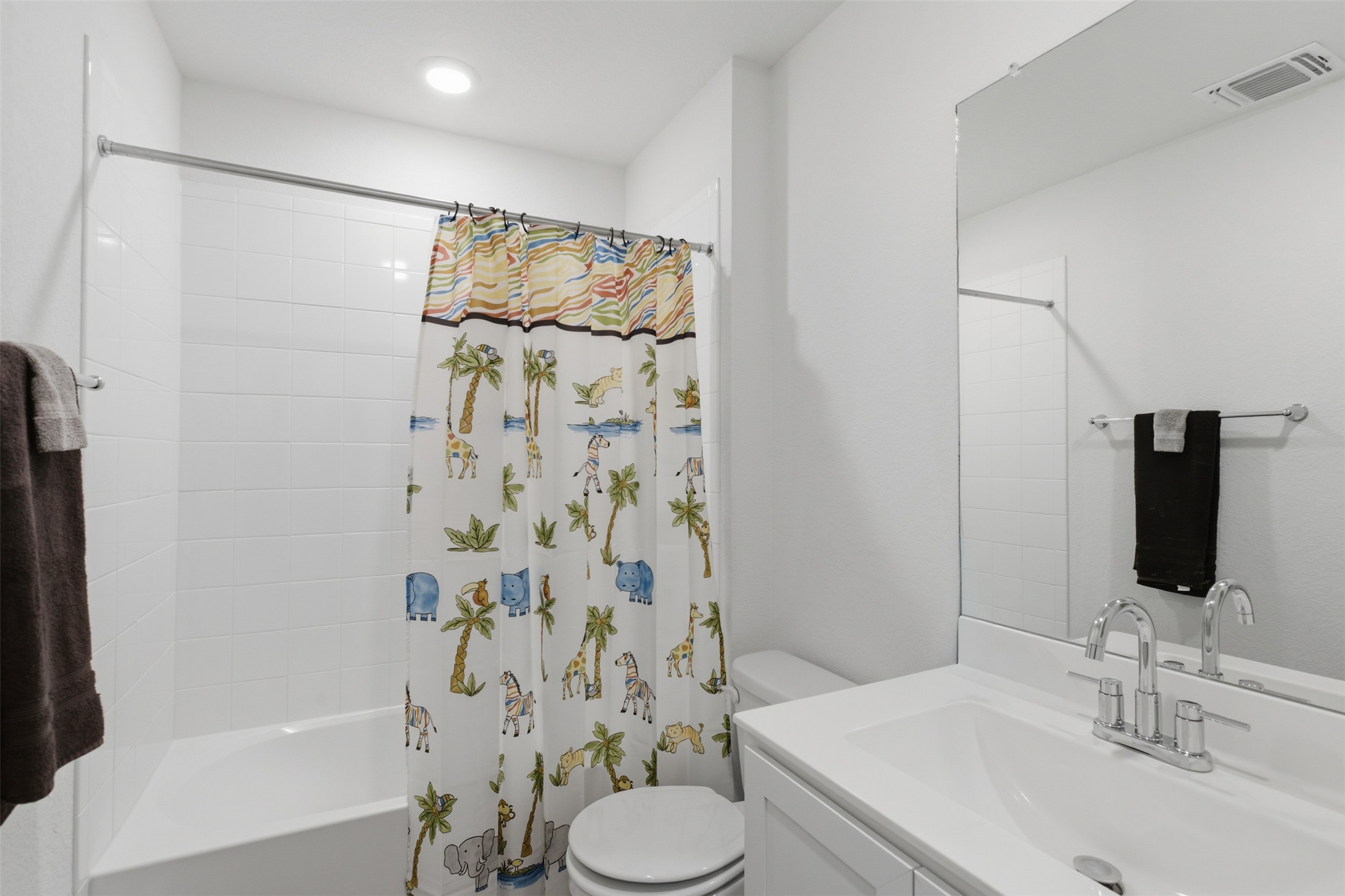 19017 Romano Drive Elgin, TX 78621 - Photo 22 of 33 Bathroom featuring a white subway tile shower surround, a built-in bathtub, and a modern vanity with an integrated sink