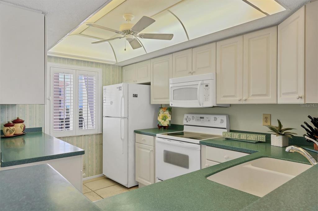 9011 Midnight Pass Road, Unit 426 Sarasota, FL 34242 - Photo 14 of 53 a kitchen with stainless steel appliances granite countertop a sink a stove a refrigerator and cabinets