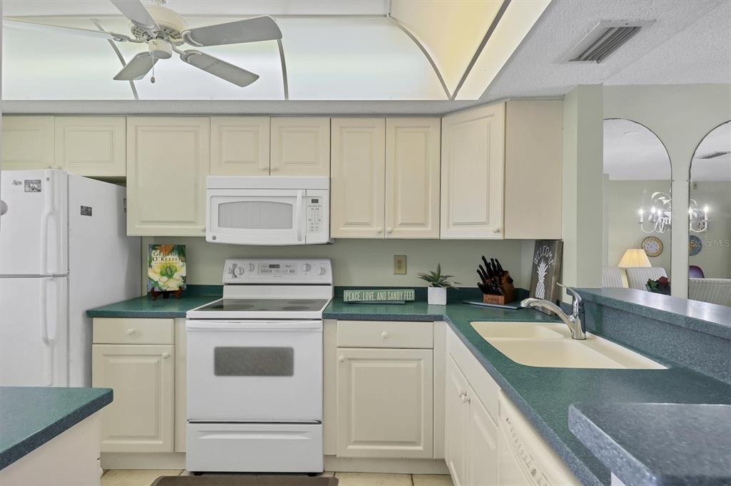 9011 Midnight Pass Road, Unit 426 Sarasota, FL 34242 - Photo 15 of 53 a kitchen with cabinets appliances a sink and a counter top space