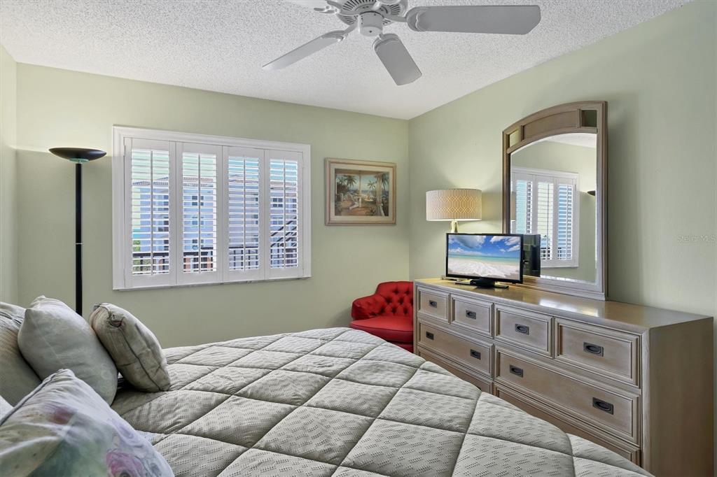 9011 Midnight Pass Road, Unit 426 Sarasota, FL 34242 - Photo 25 of 53 a bedroom with a bed a dresser and mirror