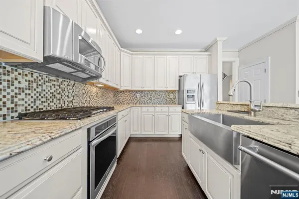 a kitchen with granite countertop white cabinets and white appliances