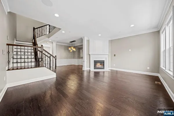 a hallway with stairs and wooden floor