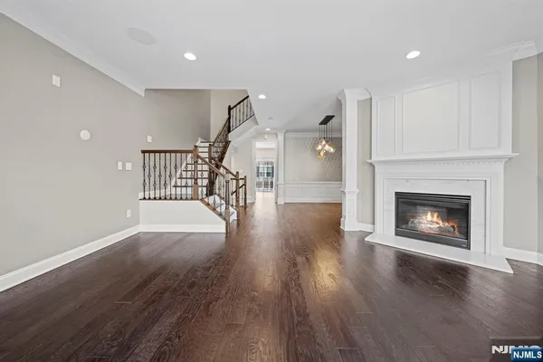 a view of a livingroom with wooden floor a fireplace and windows